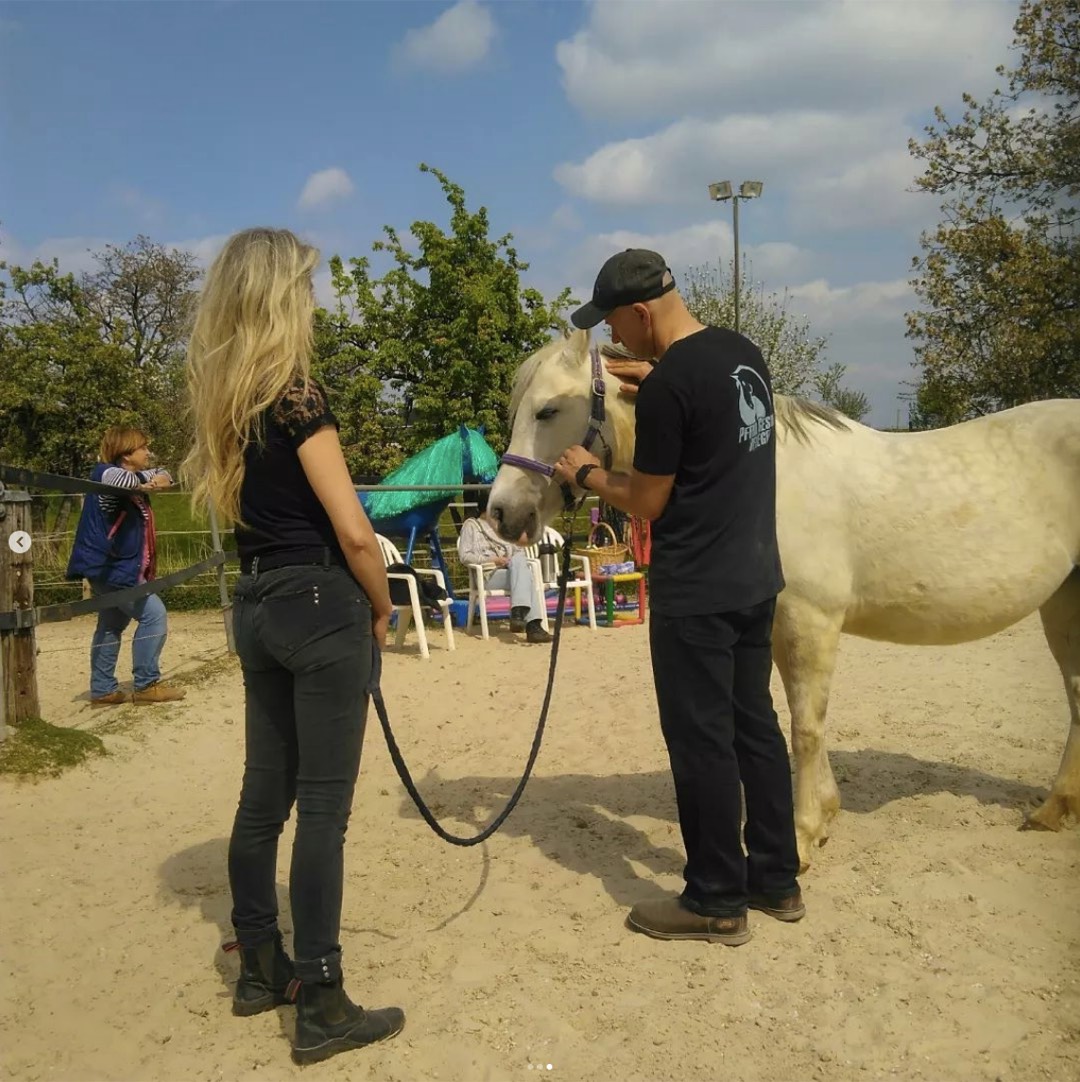 Chris Debski behandelt ein Pony im Genick, die Besitzerin schaut zu